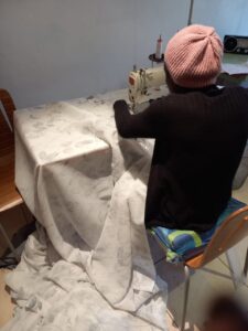 Cizen stitching wave tape onto sheers.